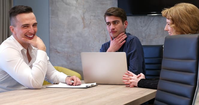 Group of a young business people discussing business plan at modern startup office building