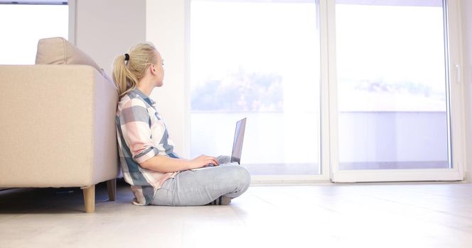 beautiful young women using laptop computer on the floor of her luxury home