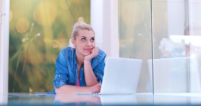 beautiful young women using laptop computer on the floor of her luxury home