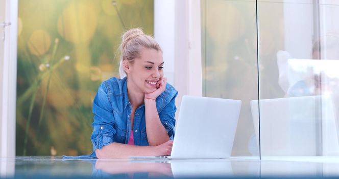 beautiful young women using laptop computer on the floor of her luxury home