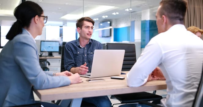 Group of a young business people discussing business plan at modern startup office building