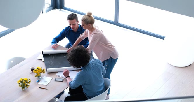 Group of a young business people discussing business plan at modern startup office building