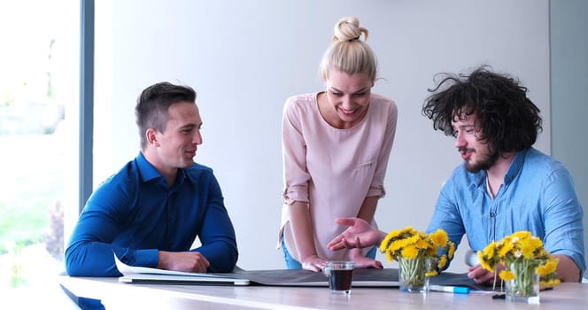 Group of a young business people discussing business plan at modern startup office building