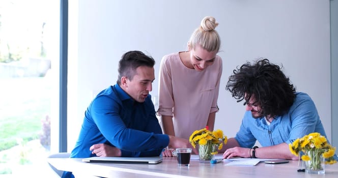 Group of a young business people discussing business plan at modern startup office building