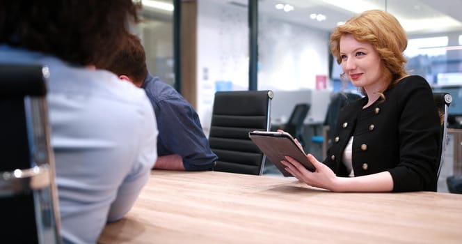 Group of a young business people discussing business plan at modern startup office building