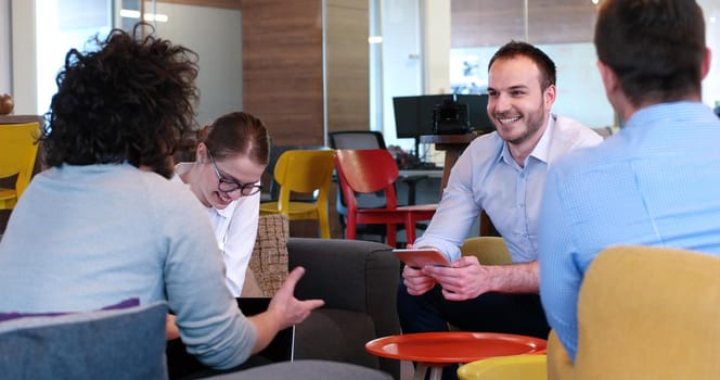 Group of a young business people discussing business plan at modern startup office building