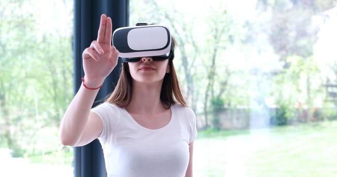 Smile happy woman getting experience using VR-headset glasses of virtual reality at home