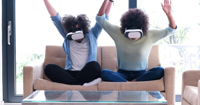 Multiethnic Couple using virtual reality headset in living room at home  people playing game with new trends technology