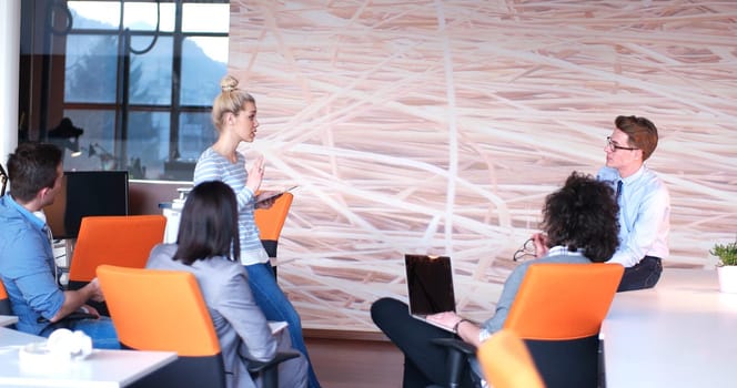 Group of a young business people discussing business plan at modern startup office building