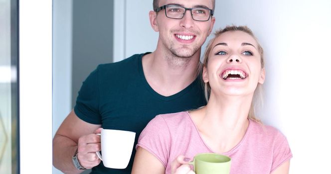 romantic happy young couple enjoying morning coffee by the window in their luxury home