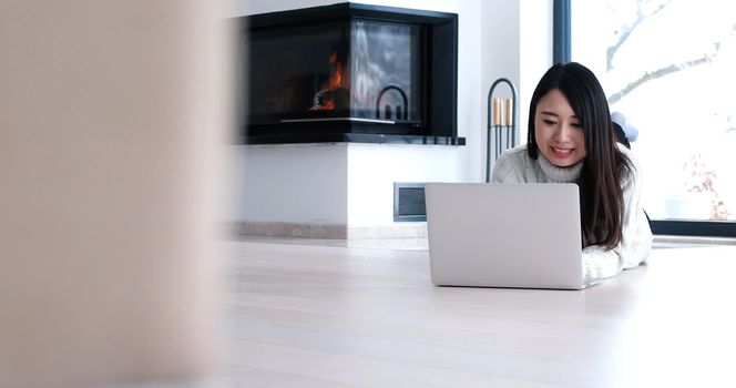 young attractive Asian woman using laptop on floor at home in the living room