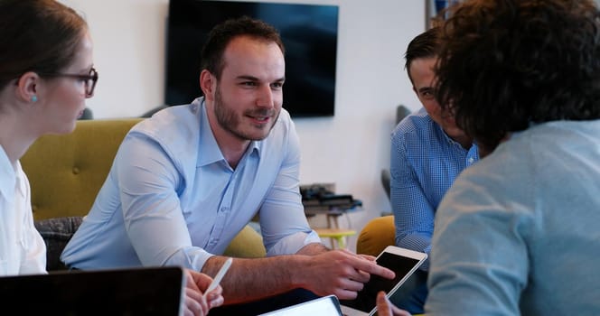 Group of a young business people discussing business plan at modern startup office building