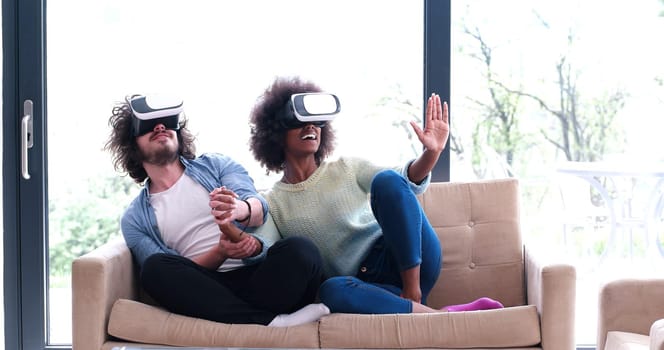 Multiethnic Couple using virtual reality headset in living room at home  people playing game with new trends technology