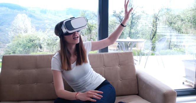 Smile happy woman getting experience using VR-headset glasses of virtual reality at home