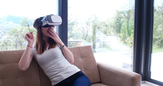 Smile happy woman getting experience using VR-headset glasses of virtual reality at home