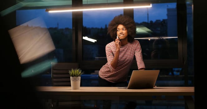 Young african american female Entrepreneur Freelancer Working Using A Laptop In night Coworking space