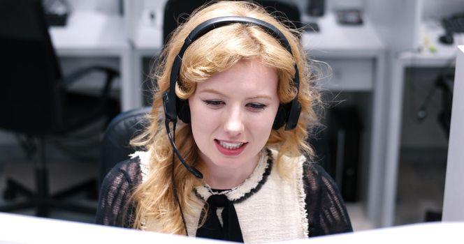 young smiling female call centre operator doing her job with a headset