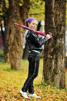 happy girl with umbrella outdoor in park on autumn season rain day