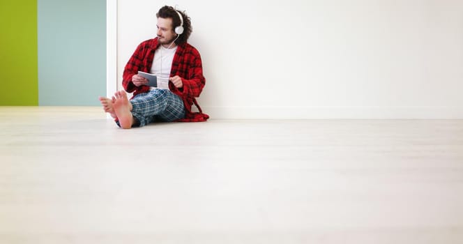 Handsome young man listenig music on tablet at  home