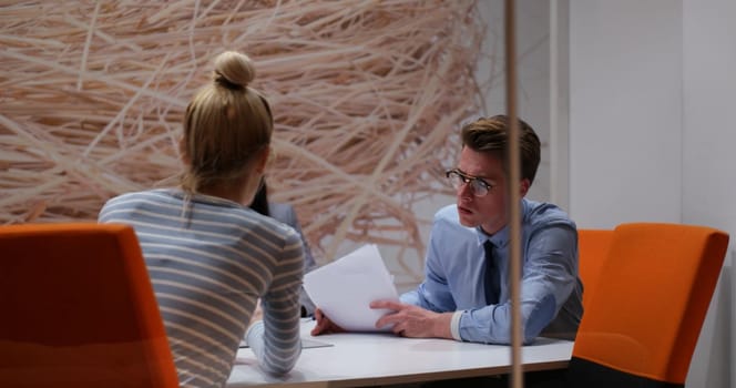 Group of a young business people discussing business plan at modern startup office building