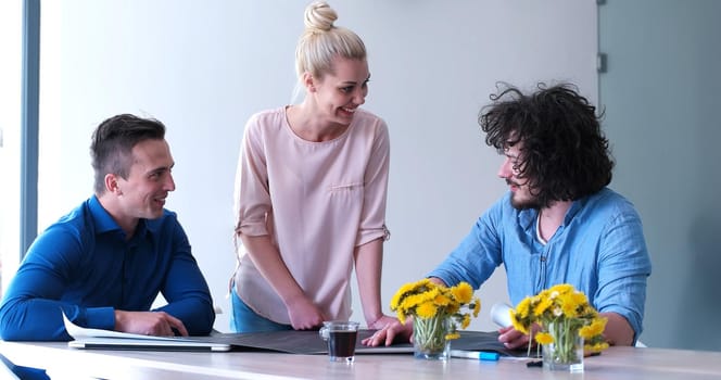 Group of a young business people discussing business plan at modern startup office building