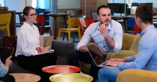 Group of a young business people discussing business plan at modern startup office building