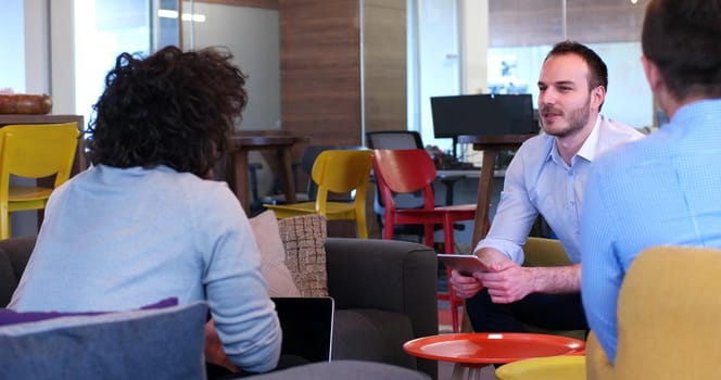 Group of a young business people discussing business plan at modern startup office building