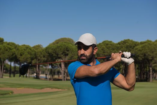 golf player hitting shot with club on course at beautiful morning with sun flare in background