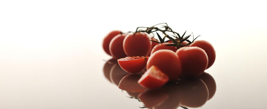 small wet fresh red tomato group isolated on white with glossy surface reflection