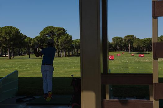 golf player practicing  shot with club on training course
