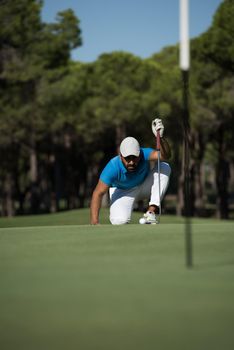 golf player aiming shot with club on course at beautiful sunny day