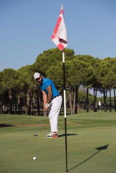 golf player hitting shot with driver on course at beautiful sunny day