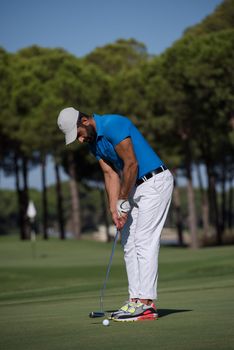 golf player hitting shot with driver on course at beautiful sunny day