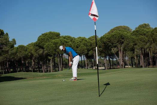 golf player hitting shot with driver on course at beautiful sunny day