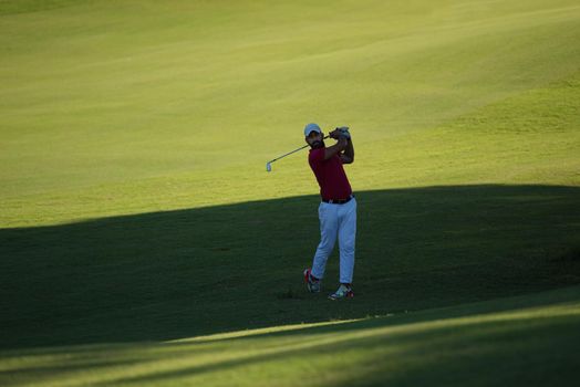 golf player hitting shot with driver on course at beautiful sunny day