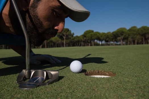 golf player blowing ball in hole. concept of cheating and success