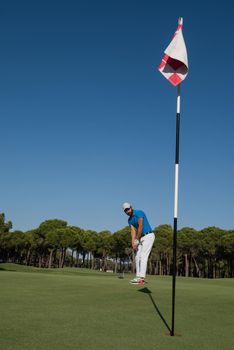 golf player hitting shot with driver on course at beautiful sunny day