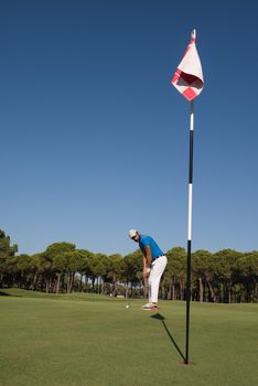 golf player hitting shot with driver on course at beautiful sunny day