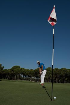 golf player hitting shot with driver on course at beautiful sunny day