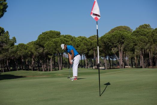 golf player hitting shot with driver on course at beautiful sunny day