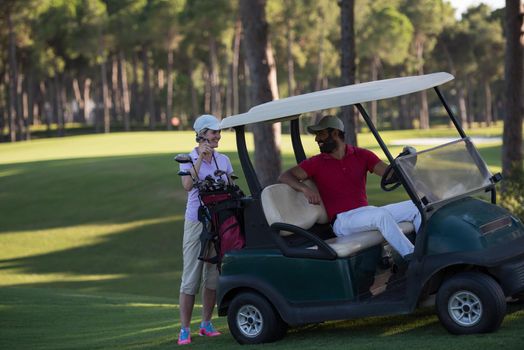 couple in buggy cart on golf course