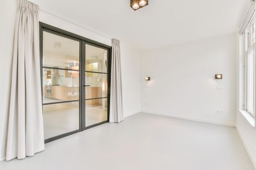 Large white room with sliding glass doors in a black frame