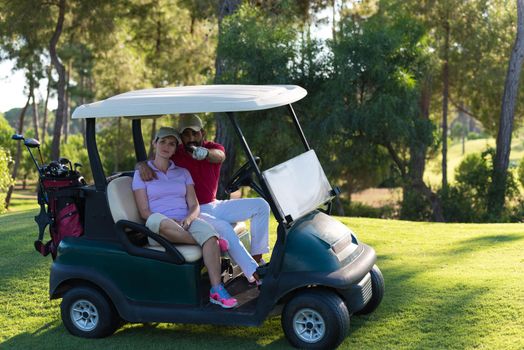 couple in buggy cart on golf course