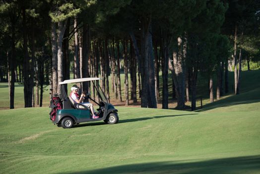couple in buggy cart on golf course
