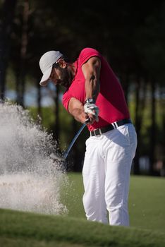 golf player shot ball from sand bunker at course