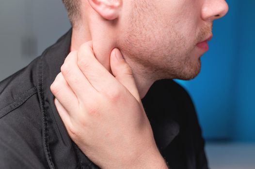 Young Caucasian male masseur doing self-neck massage to himself. Close-up. Myofasceal release.