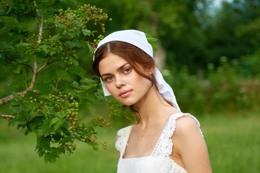 Woman in white dress in the village outdoors Green grass Farmer. High quality photo