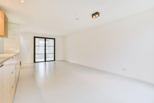 Large white room with sliding glass doors in a black frame