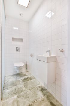 Brightly lit elongated washroom with marble floor