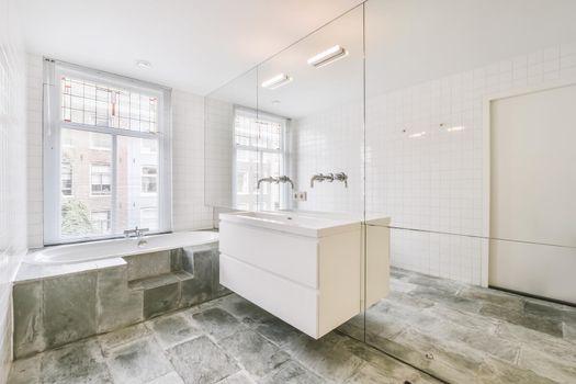 Luxurious bathroom with marble floor and bathtub near the window